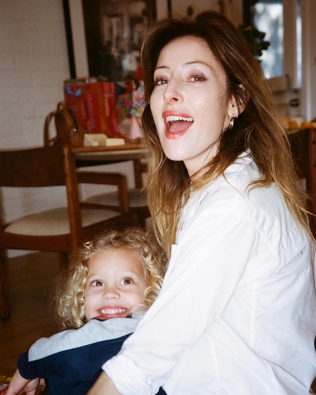 Alexandra Edenborough in a white shirt holding her daughter in her loving arms.